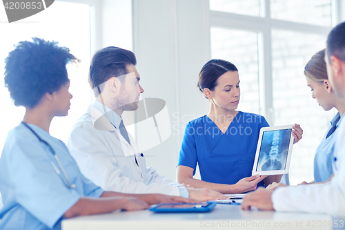 Image of group of doctors with x-ray on tablet pc at clinic