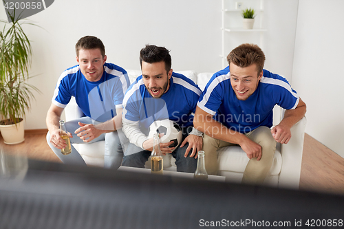 Image of friends or football fans watching soccer at home