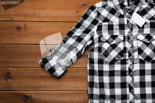 Image of close up of checkered shirt on wooden background