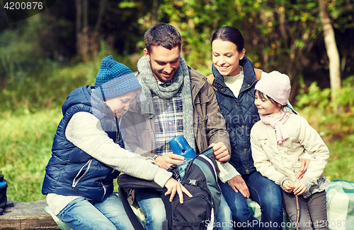 Image of happy family with backpack and thermos at camp