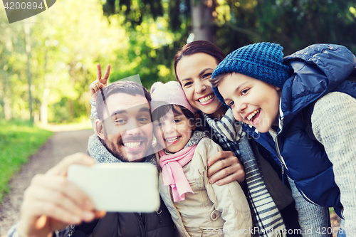 Image of family with backpacks taking selfie by smartphone