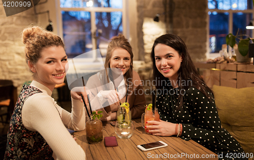 Image of happy friends with drinks at restaurant