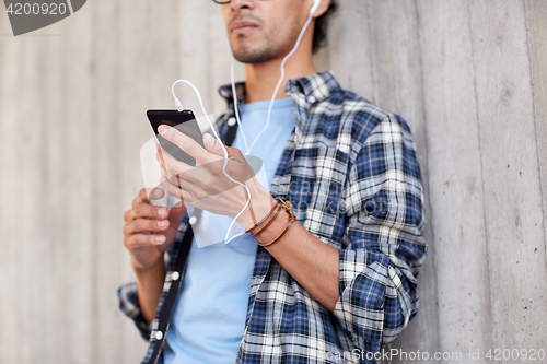 Image of man with earphones and smartphone listening music