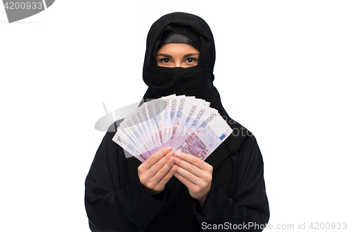 Image of muslim woman in hijab with money over white