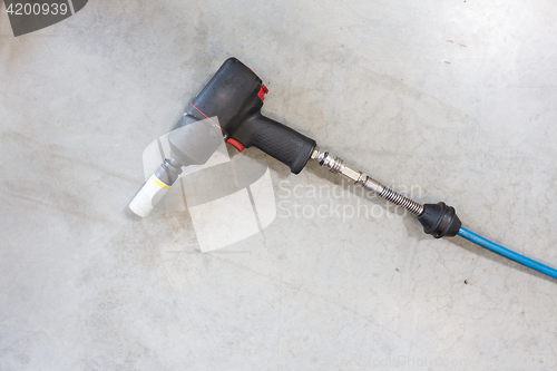 Image of screwdriver on floor at tire shop