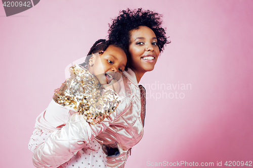 Image of young pretty african-american mother with little cute daughter hugging, happy smiling on pink background, lifestyle modern people concept 