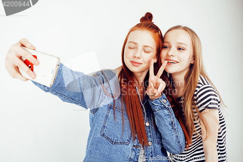 Image of lifestyle people concept: two pretty stylish modern hipster teen girl having fun together, happy smiling making selfie 