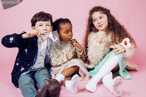 Image of lifestyle people concept: diverse nation children playing together, caucasian boy with african little girl holding candy happy smiling 