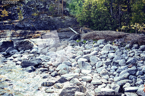 Image of wild north nature landscape. lot of rocks on lake shore