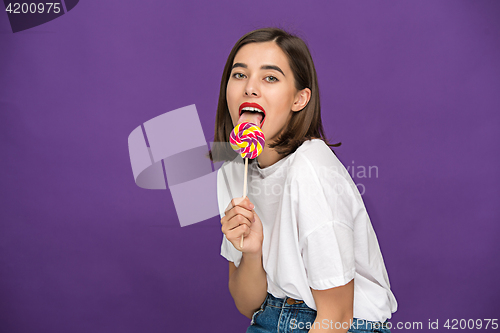 Image of The young woman with colorful lollipop