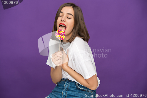 Image of The young woman with colorful lollipop