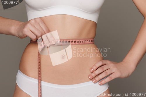 Image of The girl taking measurements of her body, white background.