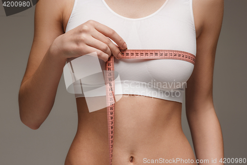 Image of The girl taking measurements of her body, white background.