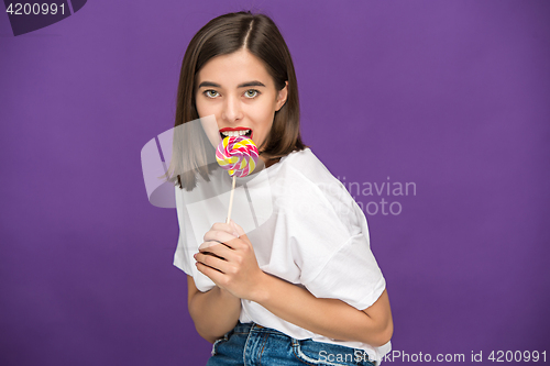 Image of The young woman with colorful lollipop