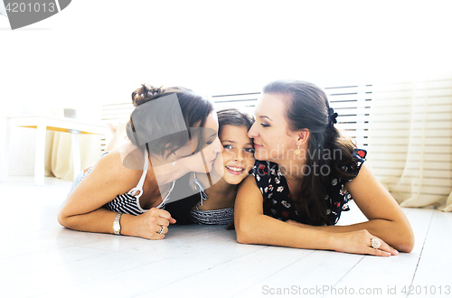 Image of Mature sisters twins at home with little daughter, happy family 