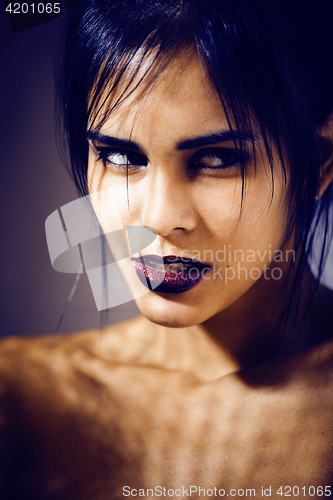 Image of pretty brunette woman with make up like demon at halloween, closeup scary background