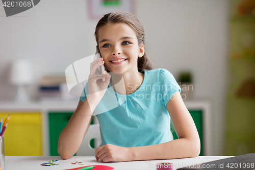 Image of happy girl calling on smartphone at home