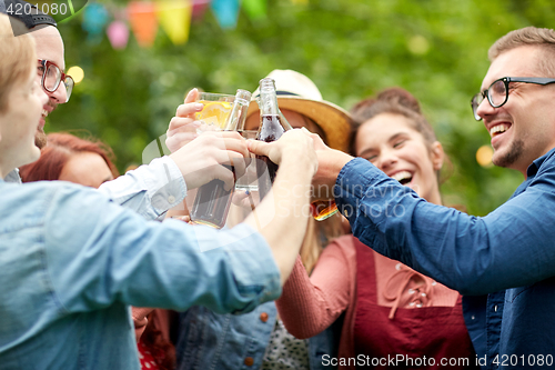 Image of happy friends clinking glasses at summer garden