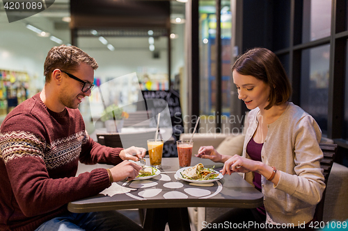 Image of happy couple eating dinner at vegan restaurant