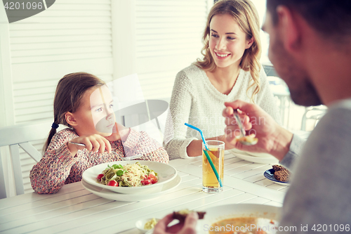 Image of happy family having dinner at restaurant or cafe