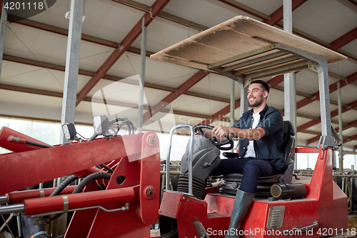 Image of man or farmer driving tractor at farm