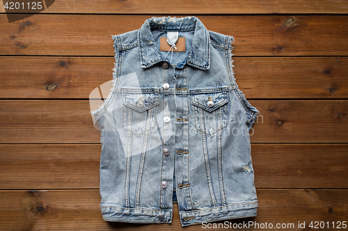 Image of denim vest or waistcoat on wooden background