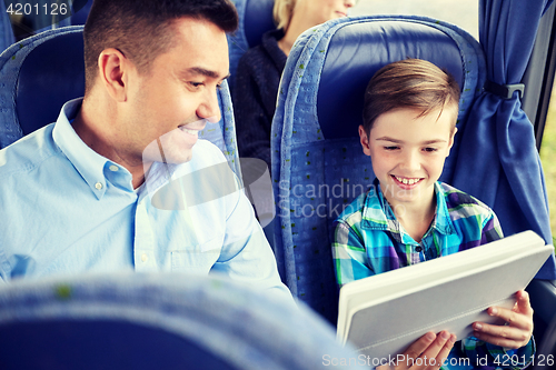 Image of happy family with tablet pc sitting in travel bus