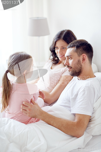 Image of happy family in bed at home