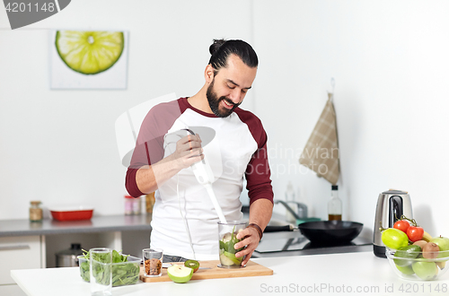 Image of man with blender cooking food at home kitchen