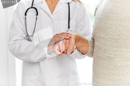 Image of close up of doctor holding old man hand