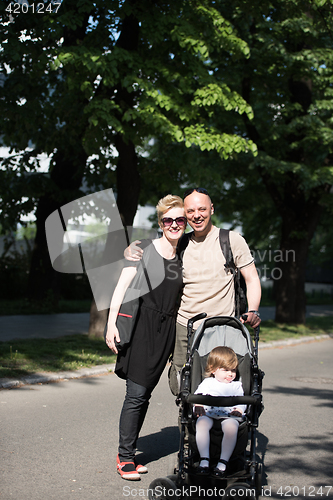 Image of couple with baby pram in summer park