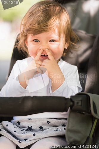 Image of baby girl sitting in the pram