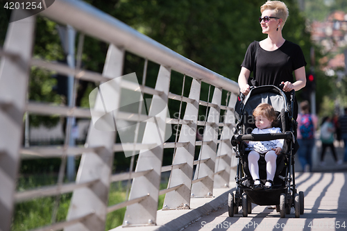 Image of mother pushed her baby daughter in a stroller