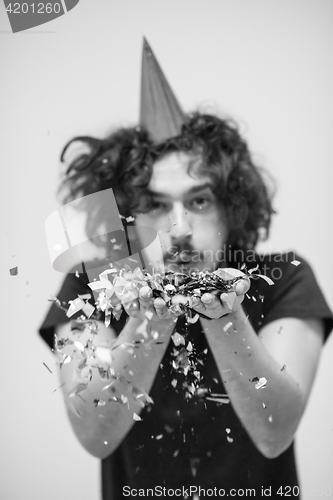 Image of man blowing confetti in the air