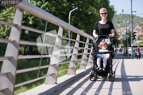 Image of mother pushed her baby daughter in a stroller