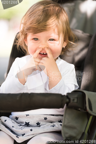 Image of baby girl sitting in the pram