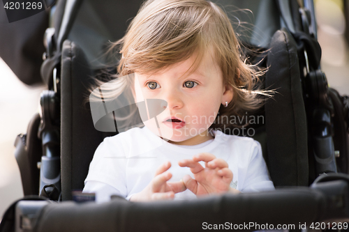 Image of baby girl sitting in the pram