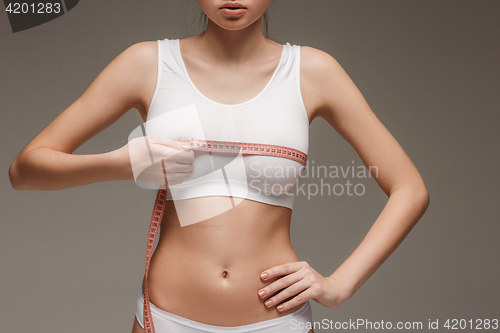 Image of The girl taking measurements of her body, white background.