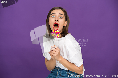 Image of The young woman with colorful lollipop