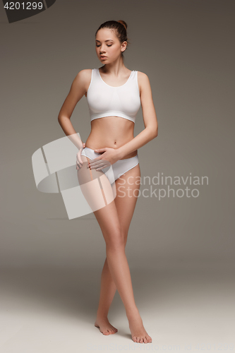 Image of Young, slim, healthy and beautiful woman in white lingerie