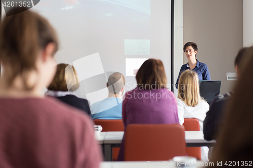 Image of Woman giving presentation in lecture hall at university.