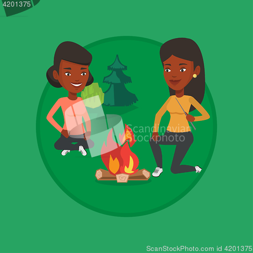 Image of Two friends sitting around bonfire in camping.