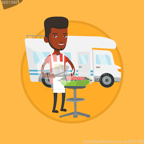 Image of Man having barbecue in front of camper van.