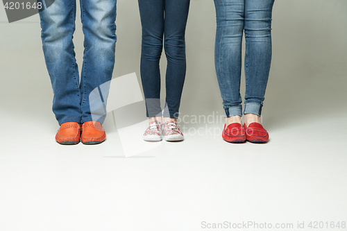 Image of  barefoot  legs of mother, father and little child wearing  jeans 