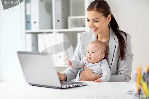 Image of happy businesswoman with baby and laptop at office