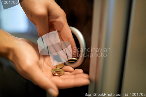 Image of hands with euro coins at vending machine