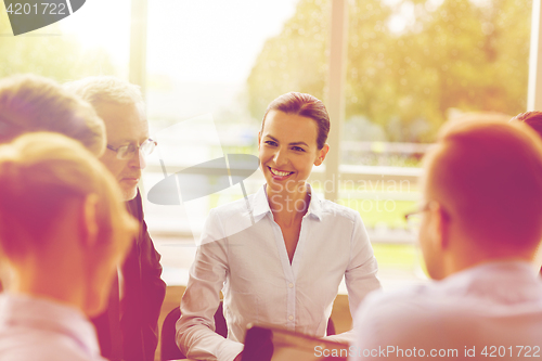 Image of smiling business people meeting in office