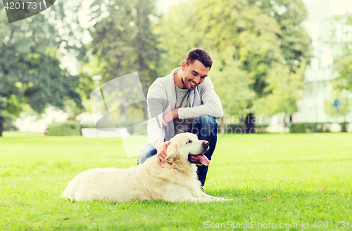 Image of happy man with labrador dog walking in city