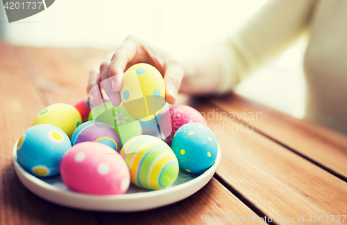 Image of close up of woman hands with colored easter eggs