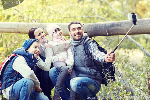 Image of happy family with smartphone selfie stick in woods